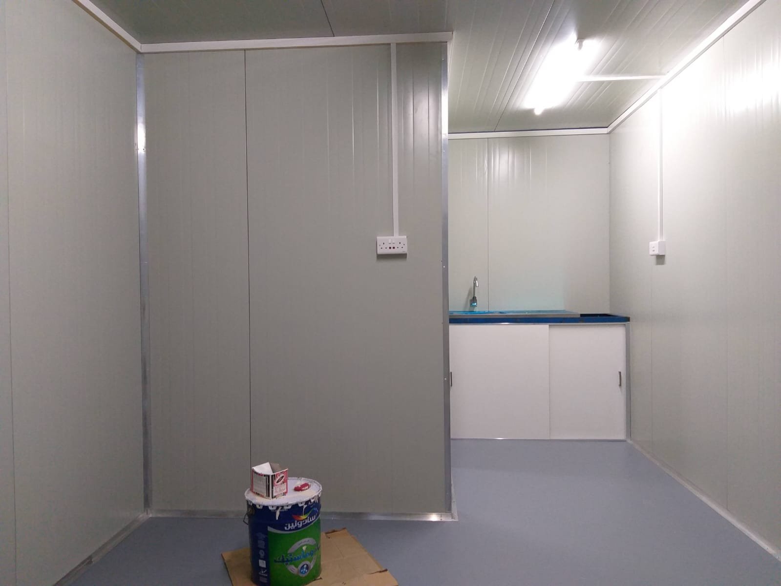 Cabin interior with grey wall panels and wash basin area